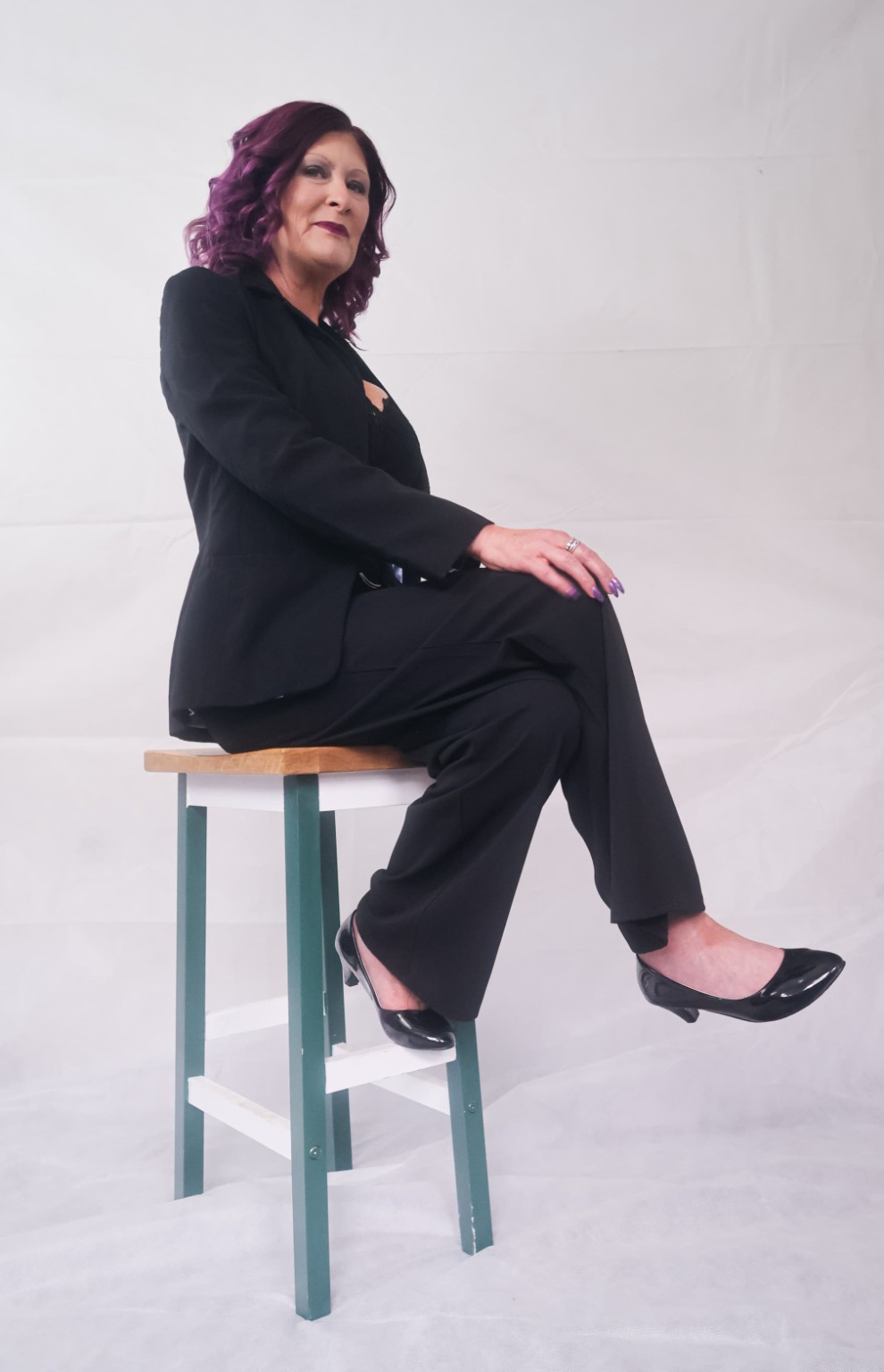 Julie seated in a tailored black trouser suit