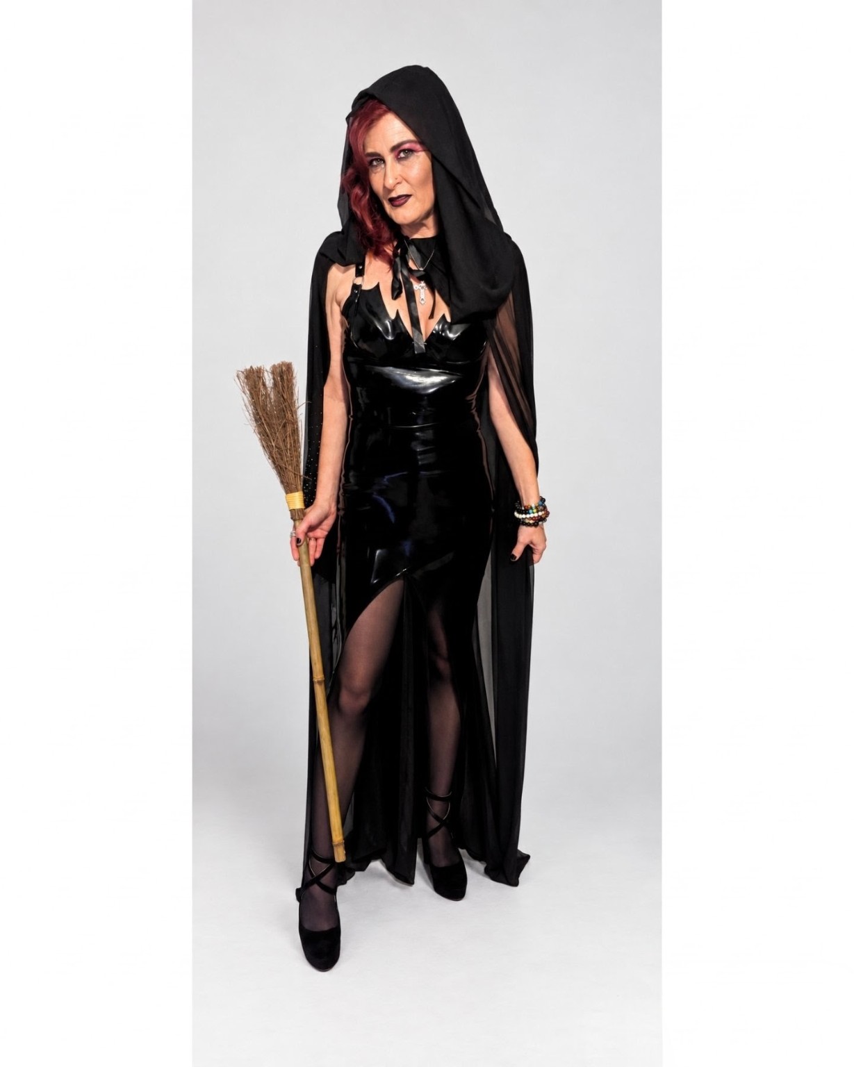 Julie in a hooded black character look with a broom
